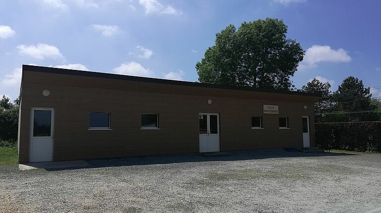 Salle Roger Plissonneau vue de l'extérieur: bâtiment en bardage bois marron foncé