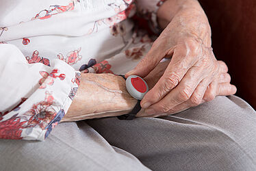 bracelet de téléassistance sur le bras d'une personne âgée