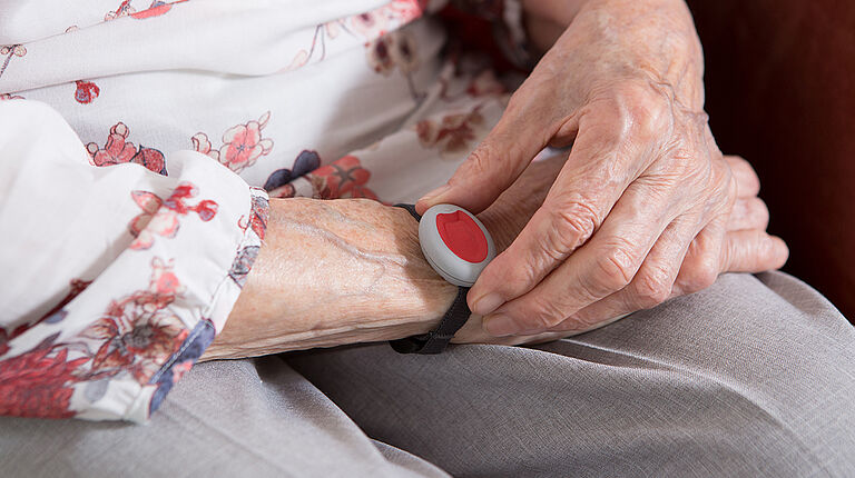 bracelet de téléassistance sur le bras d'une personne âgée