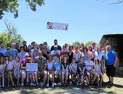 photo de groupe de personnes de tout âge en tenue estivale et à droite: un vieux four en pierre