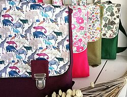 4 cartables: bordeaux, rose, et 2 verts avec tissus à motifs de fleurs ou d'animaux