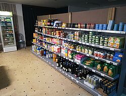 rayon d'une épicerie rempli de conserves alimentaires et de nourritures diverses 