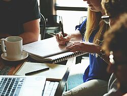 groupe de personnes assises autour d'une table en train de travailler