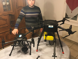 Homme avec ses drones devant lui posés sur une table