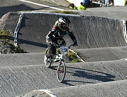 personne en combinaison et avec un casque qui pratique le bmx